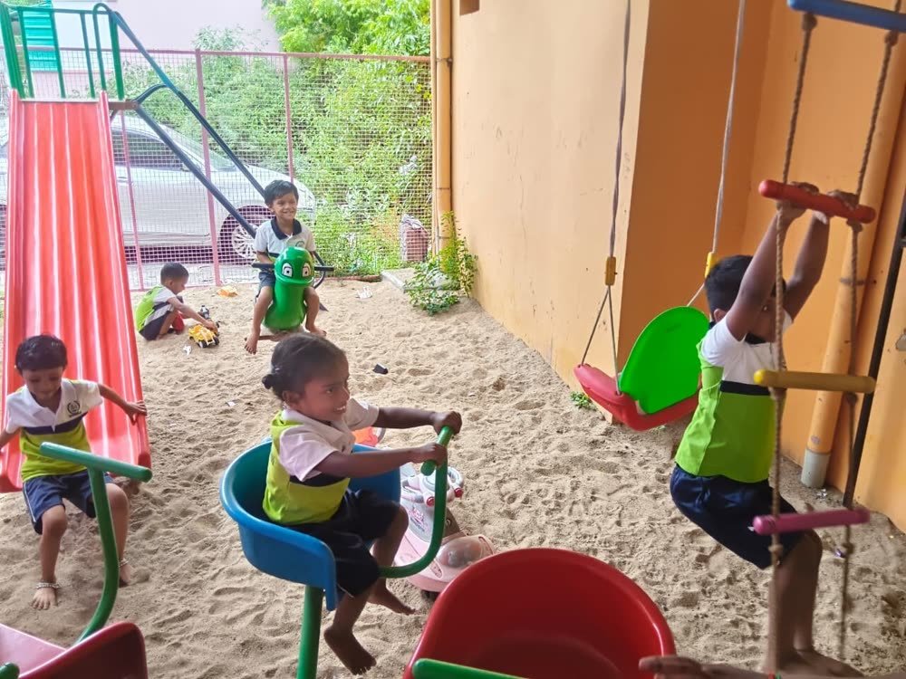 Children playing in the outdoor play area with slide and swings